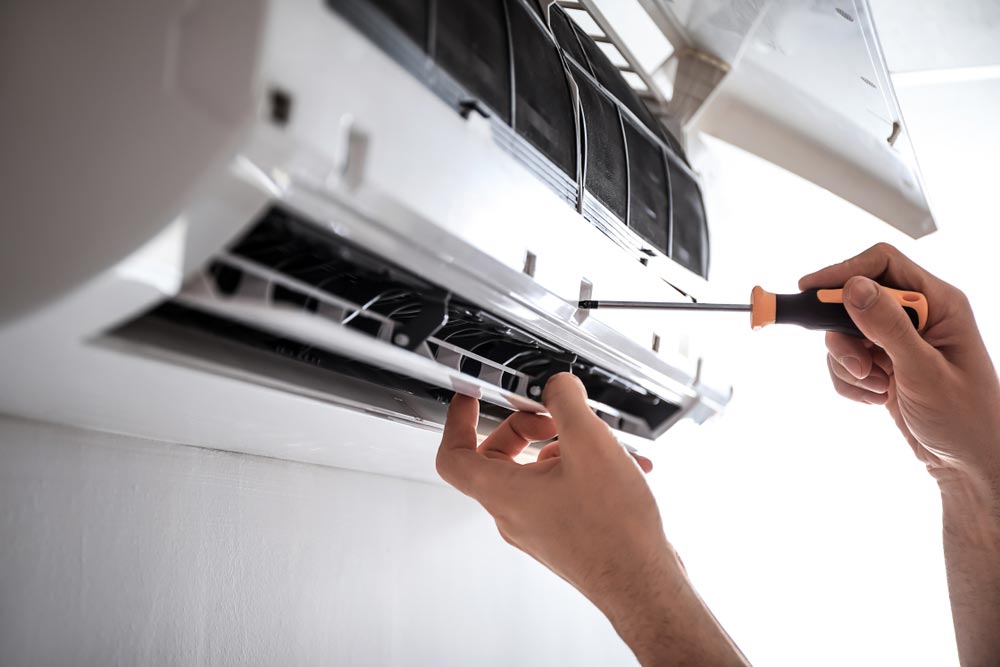 Man Repairing An Air Conditioning Unit